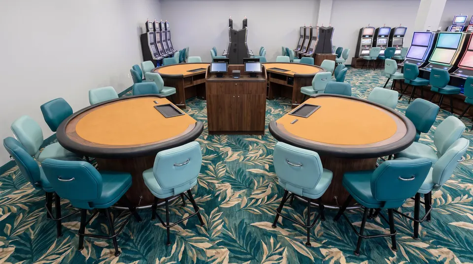 Table games with teal chairs in the resort main pit